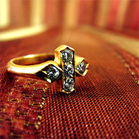 Gold cross ring with diamonds.